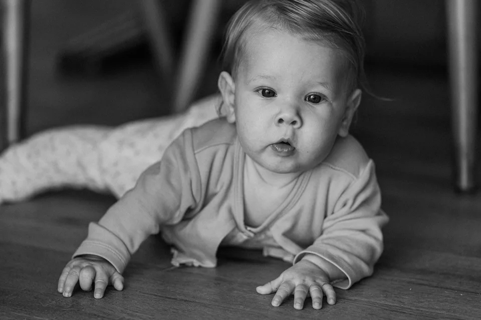 Ein Baby liegt aufmerksam auf dem Boden