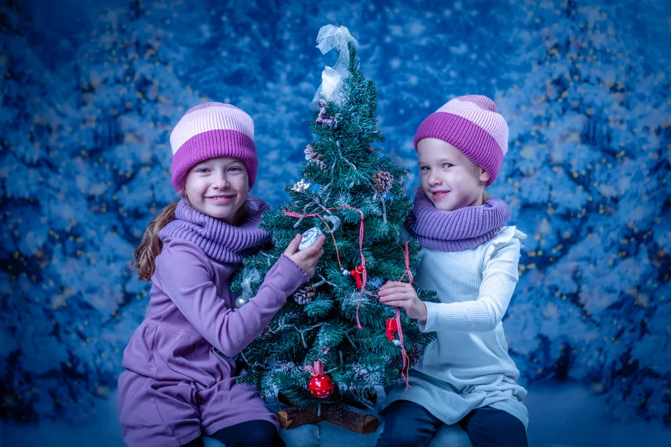 Zwei Kinder mit einem kleinen geschmückten Baum